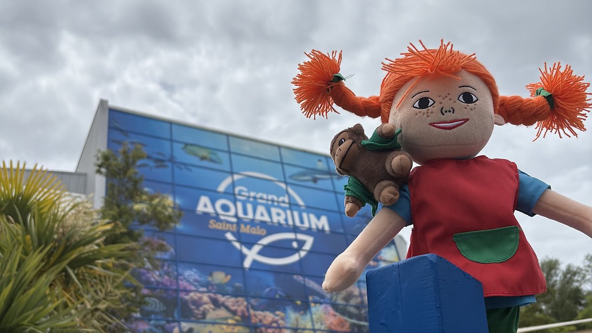 Maskoten Pippi Långstrump framför ett akvarium.